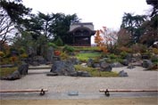Gravel, and plant beds ascending towards a low pagoda